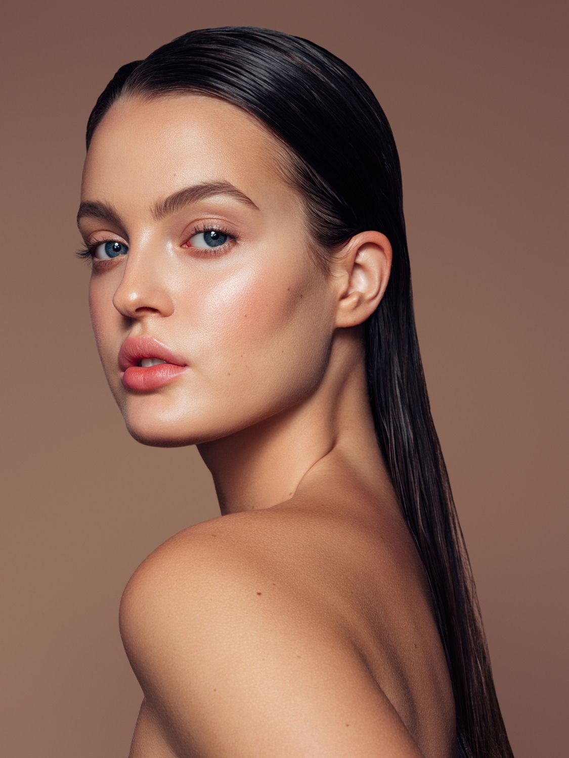 Model with green eyes touching her chin.
